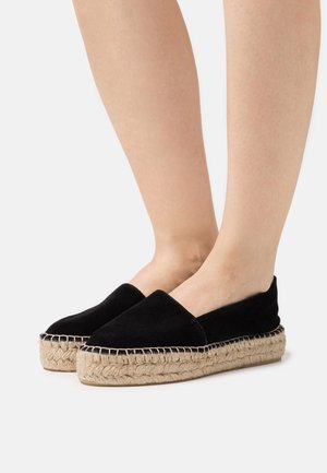 Espadrillas in suede nero con suola in corda di juta. Il design slip-on presenta una punta arrotondata e dettagli cuciti sulla suola.