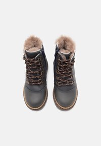 Bottines en cuir bleu foncé avec doublure en fausse fourrure marron, semelle beige et lacets marron. Présente des fermetures éclair de chaque côté pour un enfilage facile.