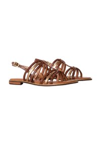 Sandales en cuir marron avec un design à lanières, dotées d'une semelle plate et d'une boucle à la cheville ajustable. Des coutures légères ajoutent du détail aux lanières.
