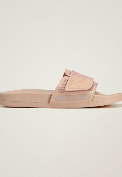 Sandale à glissière rose avec une bride texturée arborant un logo, une semelle extérieure en EVA souple et un design minimaliste. Surfaces lisses et dégradé de couleurs subtil.