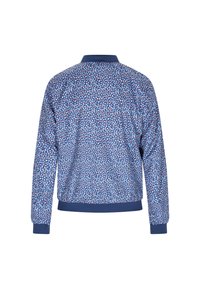 Blauwe bomberjack met een bloemenpatroon en rode en witte accenten, geribde manchetten en zoom, en een kraag. Het ontwerp benadrukt textuur en vorm.