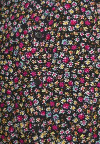 Camisa de tecido preto com um padrão floral vibrante em rosa, amarelo e azul, com botões pretos ao longo da pala frontal.
