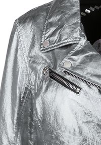 Veste de moto argentée métallique avec une finition texturée, dotée de boutons-pression, d'une poche zippée et d'un col cranté.