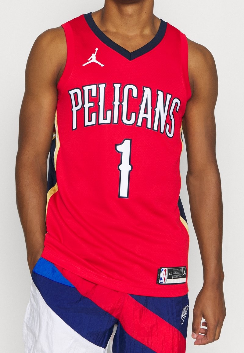 Red basketball jersey with "PELICANS" printed on the front, black accents, and a player number "1." Made of lightweight fabric with a mesh texture.