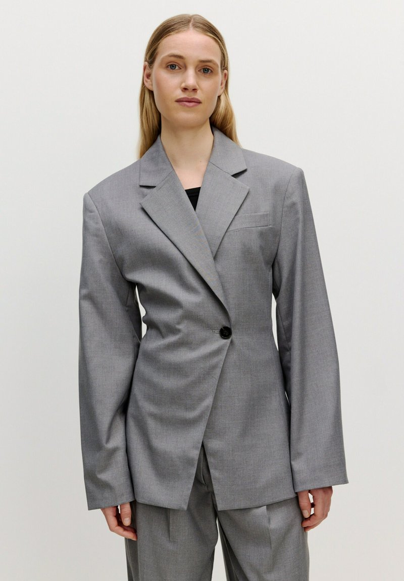 Grijze op maat gemaakte blazer met een enkele knoopsluiting, ingeknipte revers en oversized mouwen, gemaakt van een gladde, gestructureerde stof.