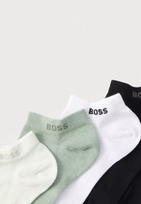 Τέσσερα ζευγάρια χαμηλά καλτσάκια σε ανοιχτό πράσινο, άσπρο και μαύρο. Κάθε ζευγάρι έχει ριμπ μανσέτα με το λογότυπο «BOSS» ανάγλυφο σε αντίθετο χρώμα.