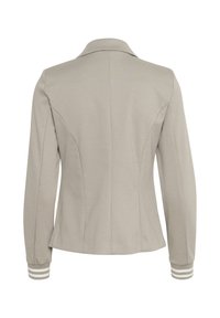 Blazer gris claro de tejido suave, con un cuello clásico, silueta ajustada y detalles a rayas en los puños.