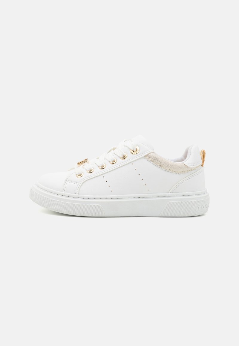 White leather sneakers with gold eyelets, beige accents, perforated detailing on the sides, and a textured white rubber sole.