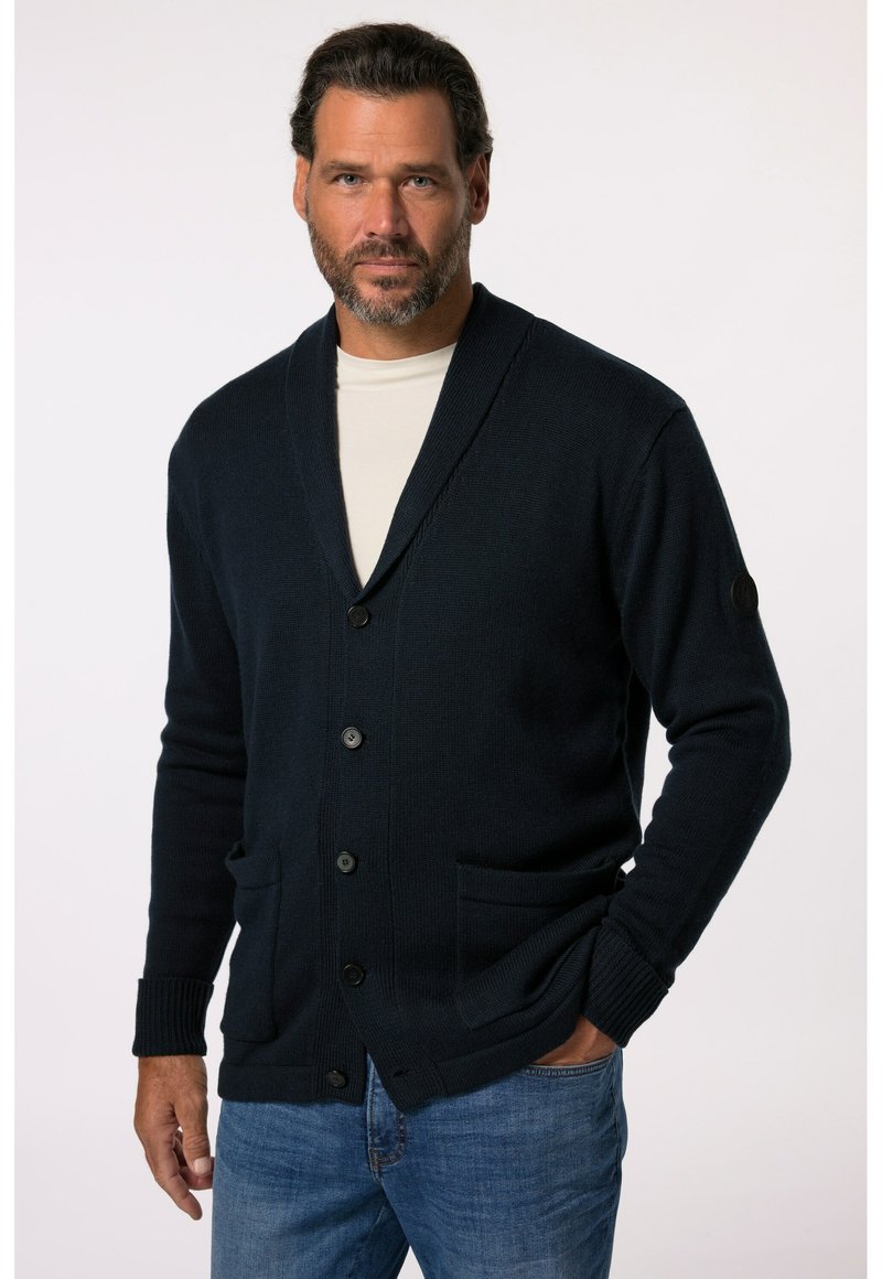 Mörkblå cardigan med sjalkrage, knappstängning och två framfickor. Ribbad mudd och strukturerat stickat tyg ger detaljer.