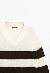 Maglione a V in crema e marrone scuro con strisce orizzontali. Tessuto a maglia, colletto a coste e vestibilità morbida. Etichetta del marchio visibile.