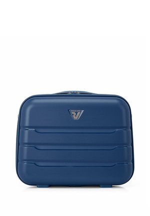 Valise rigide rectangulaire bleue avec des rainures horizontales, fermeture éclair supérieure et petit logo triangulaire de la marque au centre.