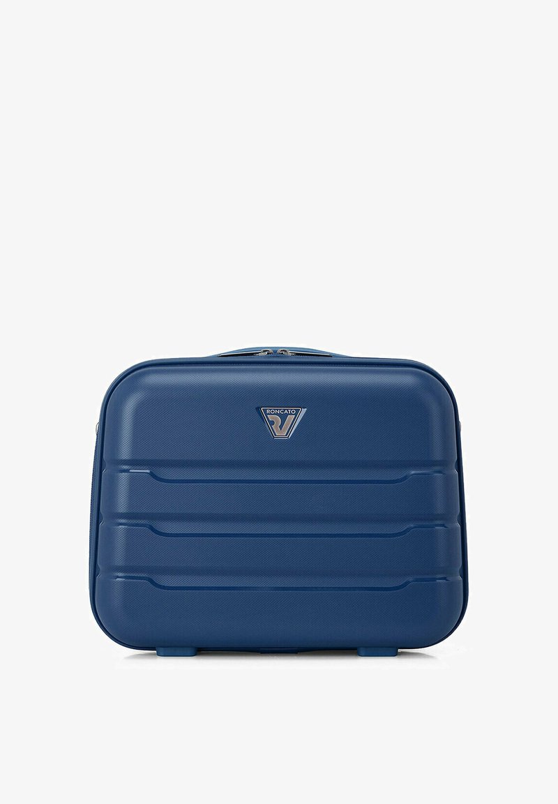 Valise rigide rectangulaire bleue avec des rainures horizontales, fermeture éclair supérieure et petit logo triangulaire de la marque au centre.
