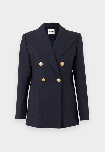 Μπλε σκούρο διπλό κουμπωτό σακάκι με φαρδιές πέτες, τέσσερα χρυσά διακοσμητικά κουμπιά και δύο μπροστινές τσέπες με ετικέτα, σε εφαρμοστή γραμμή.