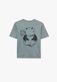 Vihreä lyhythihainen T-paita, jonka takana on musta sarjakuvamainen lohikäärme -grafiikka. Valmistettu pehmeästä, teksturoidusta puuvillasta, jossa on rento fit.