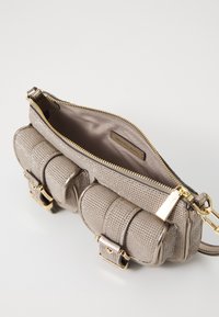 Geantă crossbody metalică bej, cu închidere cu fermoar, având un exterior texturat, două buzunare frontale și accente de hardware în ton auriu.