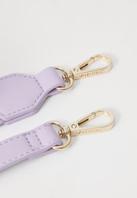 Lavanda kožna traka s zlatnim hardverom; ima heksagonalnu točku za pričvršćivanje i detalje šivanja. Ugravirano "VALENTINO" na kopčama.