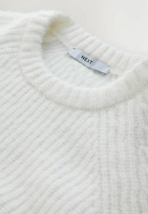 Fehér bordázott pulóver puha, bolyhos anyagból, kerek nyakkivágással. Varrt címkéje "NEXT" felirattal ellátott.