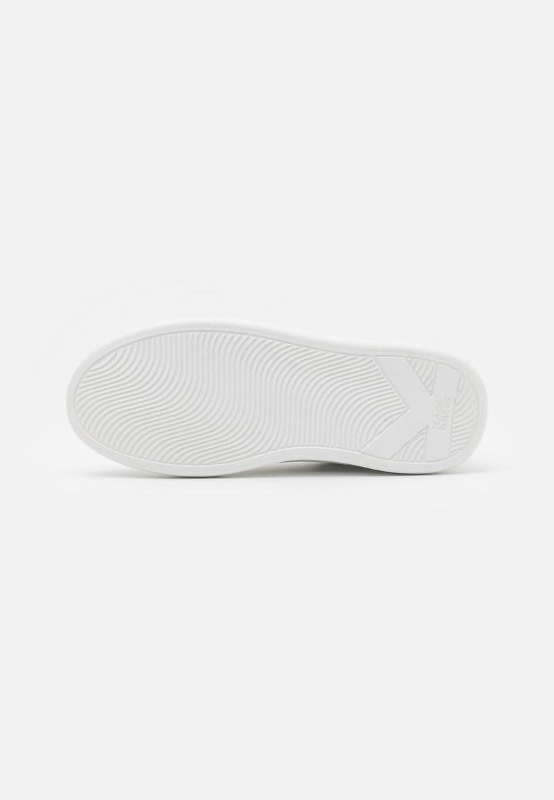 Semelle de chaussure en caoutchouc blanc avec un motif ondulé texturé et un logo de marque bien en vue. Le bord est légèrement surélevé avec une finition lisse.