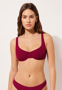 Bordeauxfarbener Bikini-Oberteil aus strukturiertem Stoff mit breiten Trägern und Unterst&uuml;tzungen durch Unterdraht. Entworfen mit einem gerafften Detail in der Mitte.