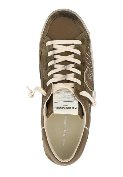 Bruine suède sneaker met beige veters, witte rubberen zool, logo op de tong en textielen voering. Bevat stijlvolle stiksels en unieke accenten.