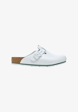 White clogs made of synthetic material with a cork footbed, adjustable strap, and a green accent on the sole. Smooth texture overall.