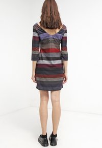 Robe rayée à manches trois quarts, dos en V. Les couleurs incluent le violet foncé, le rouge, le gris et le noir. Texture douce, design jusqu'aux genoux.