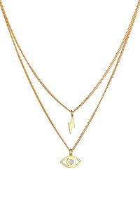 Collier superposé en ton doré avec un pendentif en forme d'éclair et un œil, orné d'une gemme claire au centre. Maillons de chaîne texturés.
