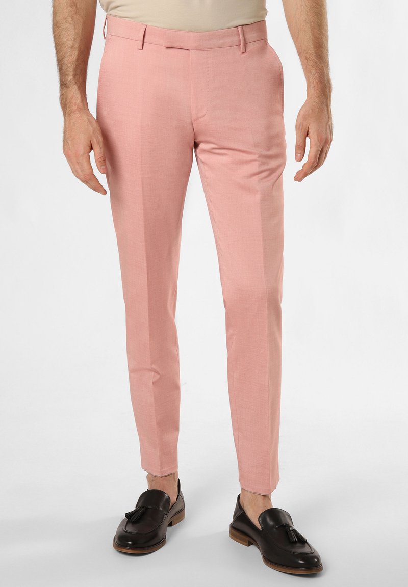 Pantaloni tailored rosa chiaro con un fit slim, realizzati in un tessuto testurizzato, presentano tasche laterali e sono abbinati a mocassini scuri.