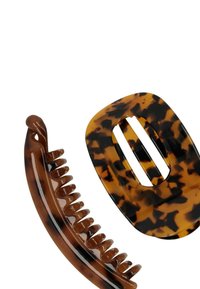 Il set di accessori per capelli tartarugati include una clip per capelli piatta con un'apertura ovale e un pettine curvo con denti fini, entrambi in tonalità marroni.