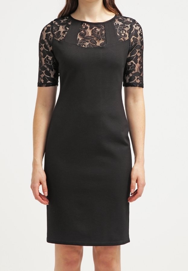 Svart klänning med en figursydd silhuett, med korta ärmar i spets och rund halsringning. Texturerat spetsmönster framhäver den övre delen.