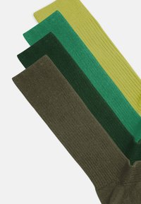 Calcetines acanalados en cuatro tonos de verde: oliva, verde oscuro, azul verdoso y verde brillante, con un suave tejido de punto texturizado y puntera reforzada.