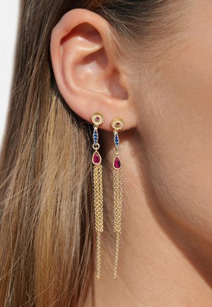Goldene HängehOhrringe mit floralen Verzierungen, roten und blauen Edelsteinen und herabfallenden Kettenakzenten. Das Design ist kunstvoll und elegant.
