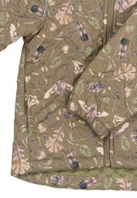 Oliiviroheline isoleeritud jakk, millel on loodusteemaline trükk lehtede, putukate ja tammetõrudega. Varustatud esi-zipi ja elastsete varrukaservadega.