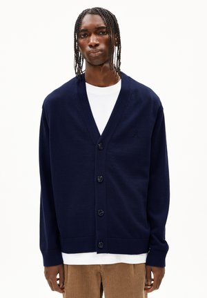 Navy button-up cardigan made of soft fabric, featuring a V-neck design, long sleeves, and a subtle knitted pattern on the shoulders.