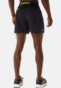 Zwarte hardloopshorts voor heren van een gestructureerde stof, met een verstelbare tailleband en een gele ritsvak aan de achterkant.