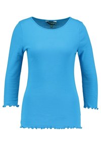 Blå långärmad topp tillverkad av elastisk tyg. Har en rund halsringning och vågkantade kanter vid ärmar och nederkant. Enkelt design.