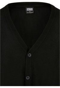 Czarny dzianinowy kardigan z dekoltem w kształcie V, z dwoma czarnymi guzikami i ribbowanym kołnierzem. Metka wskazuje "Urban Classics", rozmiar M, wyprodukowano w Bangladeszu.
