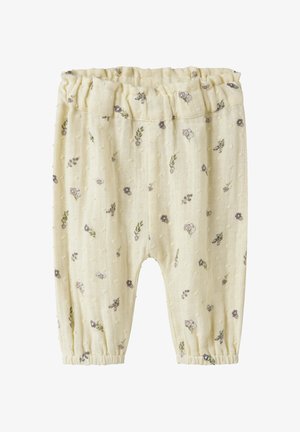 Bløde cremefarvede babybukser med små lilla og grønne blomsterprint samt elastisk talje og ankelmanchetter.