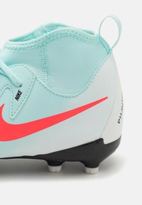 Nike Phantom jalkapallokengät, joissa on vaaleansininen päällinen, neonpinkki logo, musta pohja ja teksturoitu pinta, sekä vetonarun tuella kantapäässä.