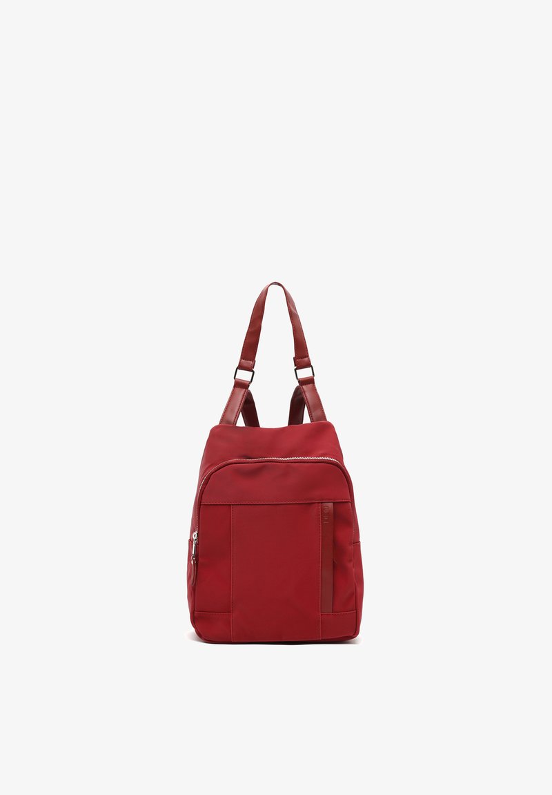 Mochila de nylon roja con correas dobles ajustables, bolsillo frontal con cremallera y textura suave. Presenta un diseño aerodinámico y un hardware mínimo.