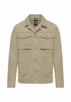 Beżowa kurtka na guziki z dwoma klapowanymi kieszeniami na piersi, dwiema kieszeniami bocznymi, długimi rękawami i kołnierzem, prezentowana na białym tle.