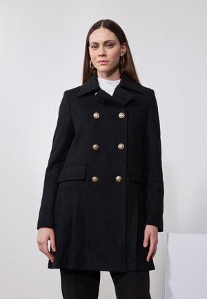 Cappotto nero doppiopetto realizzato in un tessuto testurizzato, con bottoni dorati, tasche laterali e colletto a scollo a V.