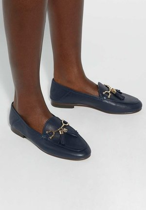Navy blue leather loafers with a flat sole, featuring gold-tone hardware and tassels on the front. Smooth texture and simple design.
