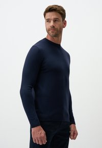 Maglione blu navy realizzato in morbido tessuto a maglia, caratterizzato da maniche lunghe, collo a giro e polsini e orlo a costine. Design dal taglio classico.