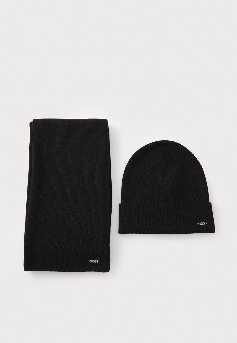 Black knit scarf and beanie, both featuring a ribbed texture. The beanie has a folded cuff and a small logo detail on the edge.
