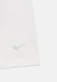 Bijela sportska tkanina sa glatkom teksturom. Sadrži suptilan sivi Nike swoosh logo u donjem lijevom kutu.