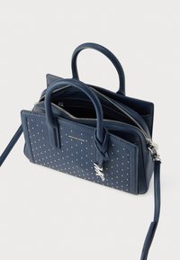 Τσάντα ώμου από δέρμα σε μπλε ναυτικό χρώμα με διακοσμητικά καρφάκια, διπλές λαβές στο επάνω μέρος, κλείσιμο με φερμουάρ, αποσπώμενο λουρί ώμου και λογότυπο στο μπροστινό μέρος.