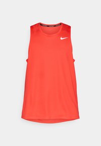 Vörös, ujjatlan sportos trikó sima anyagból, kerek nyakkivágással, a bal felső mellrészén fehér Nike logóval.