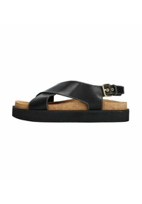 Sandale en cuir noir avec un design à lanières croisées, semelle en liège et épaisse semelle en caoutchouc noir. Présente un détail de boucle en ton doré.