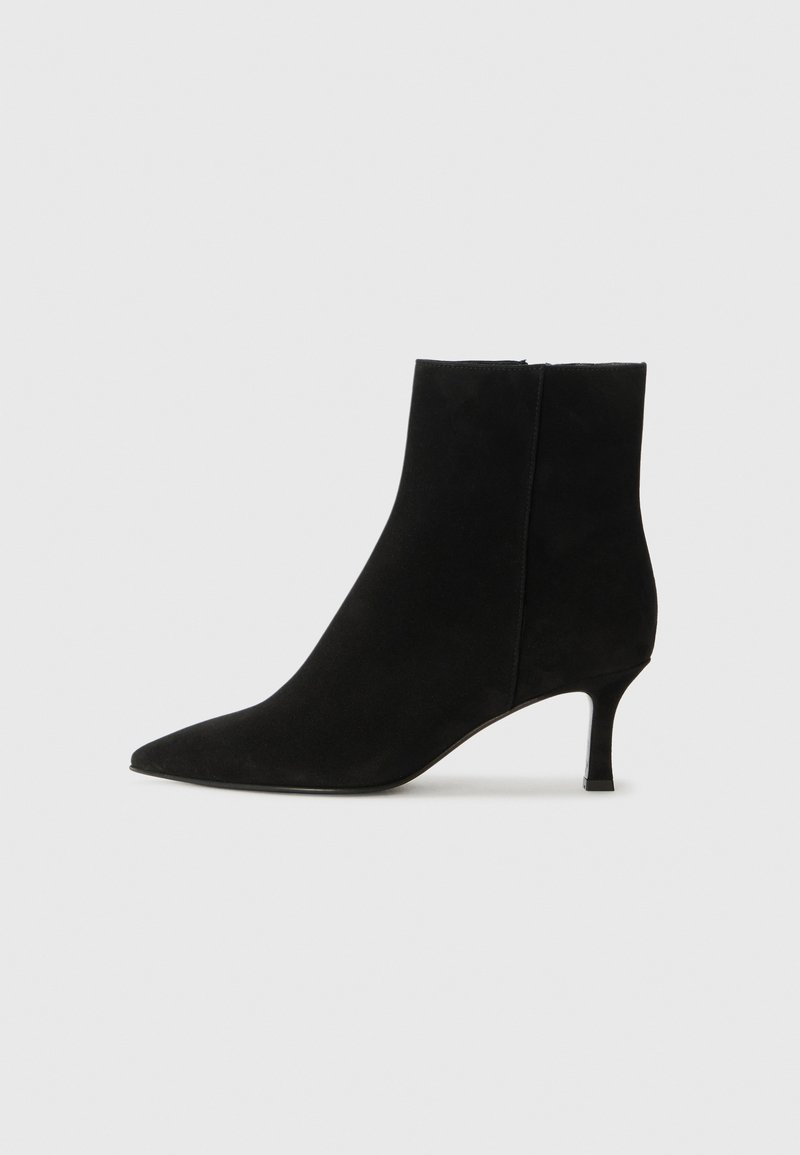 Bottines en suède noir avec un bout pointu et un talon fin. Présente une silhouette élégante avec une texture lisse et sans quincaillerie visible.